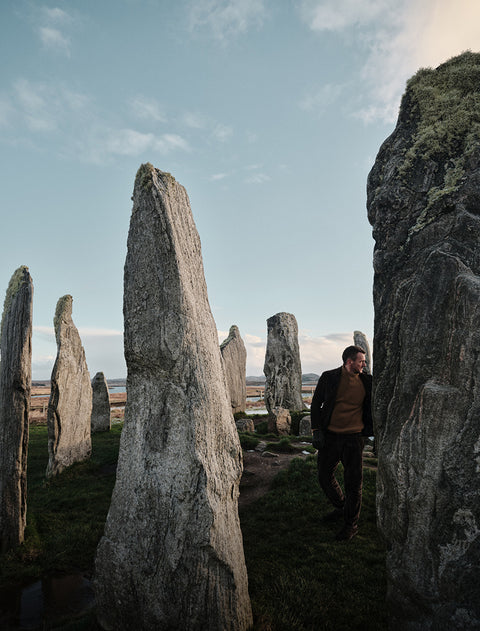 Floris van bommel standing among ancient stone monuments in a rugged landscape