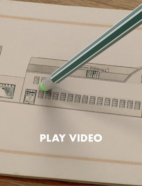 A close-up of a green and white striped drawing pencil with a green eraser tip resting on a beige sketchbook page with a line drawing. The text 'PLAY VIDEO' is overlaid at the bottom.